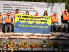 Activisten en slachtoffers staan voor wat een monument voor klimaatslachtoffers zal zijn